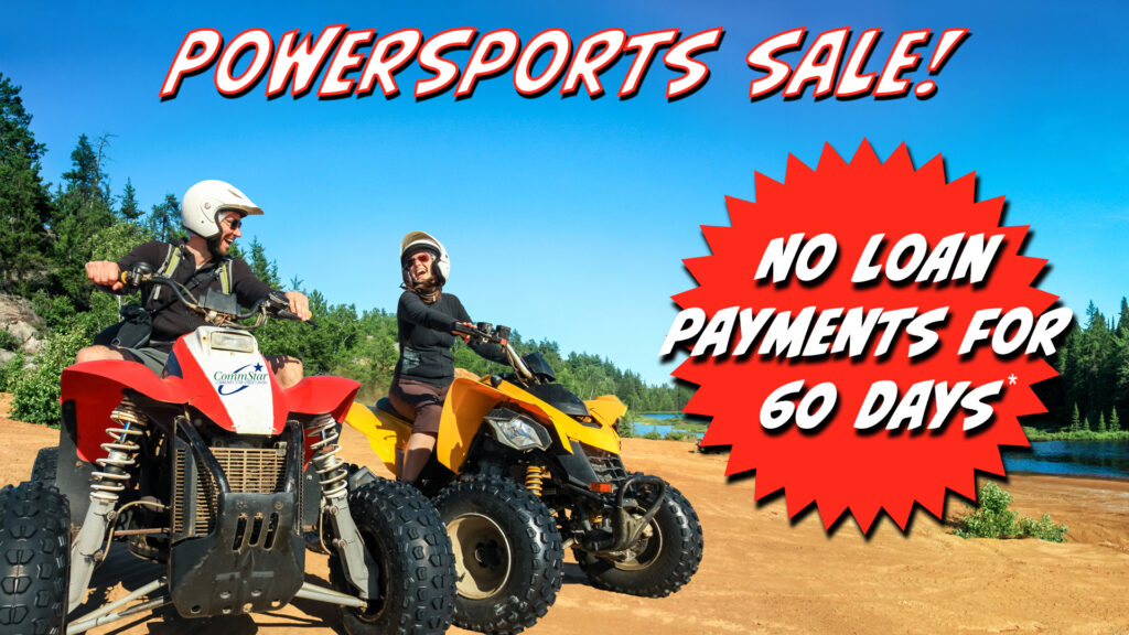 Image: Man in a white helmet on a red ATV smiling at a woman in a white helmet on a yellow ATV, on dirt near a river with trees in the background and a blue sky. Text: Powersports sale! No loan payments for 60 Days*.